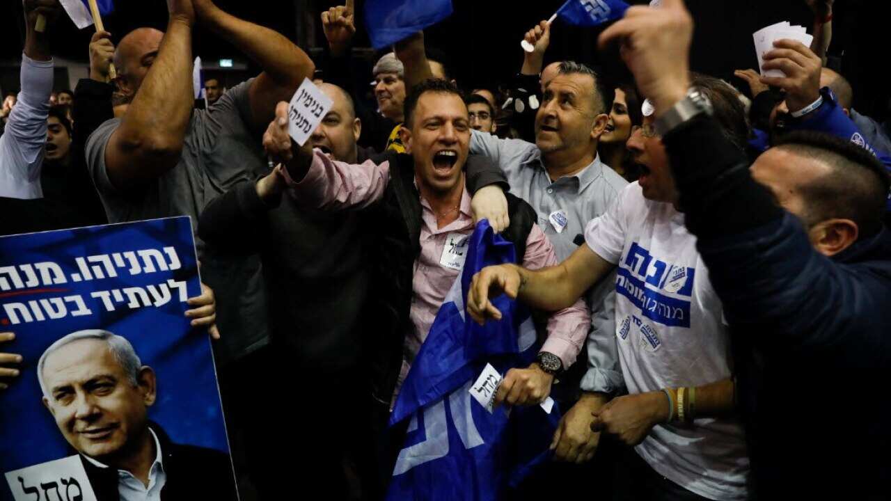 Israeli Prime Minister Benjamin Netanyahu's supporters celebrate first exit poll results for the Israeli elections at his party's headquarters in Tel Aviv