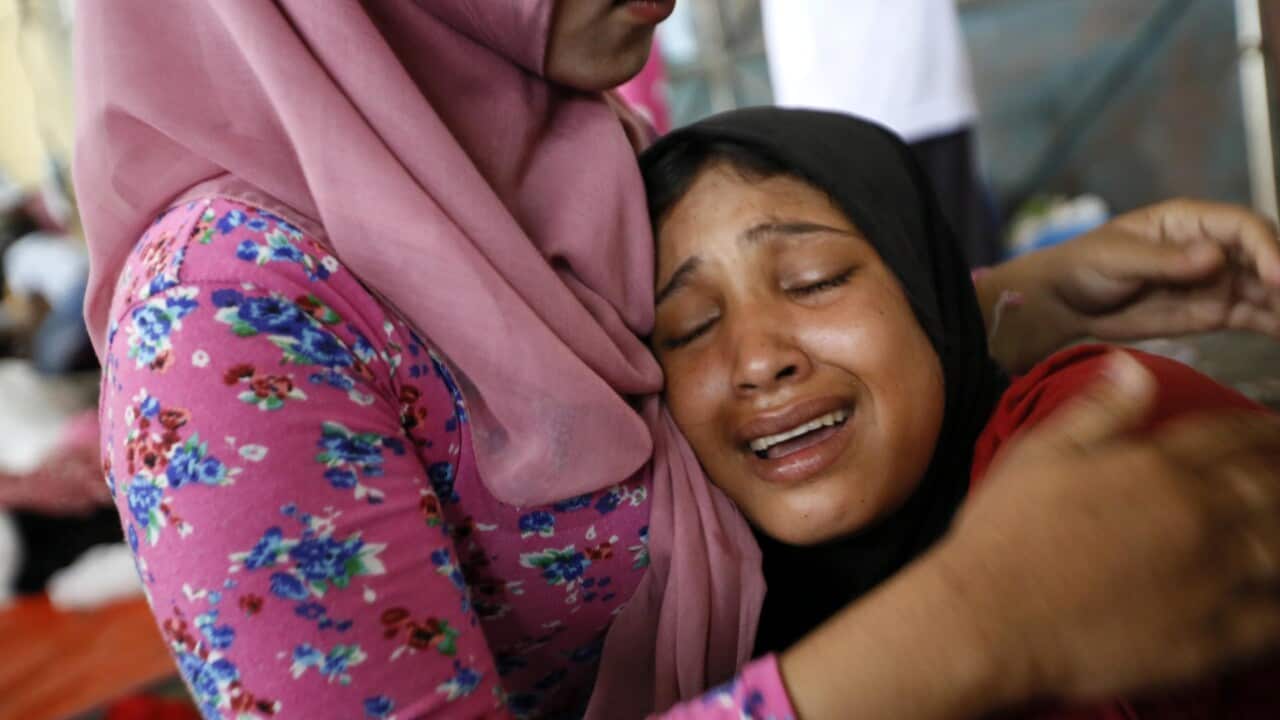 Somirahatun (R), a Myanmar migrant mourns as she lost her baby during her journey at sea, at a temporary shelter in Kuala Langsa, Aceh. (EPA)