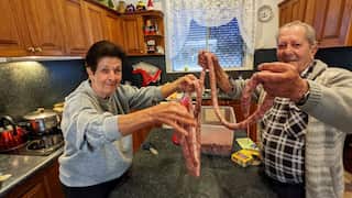 Italian Australian grandparents holding Sicilian sausages.