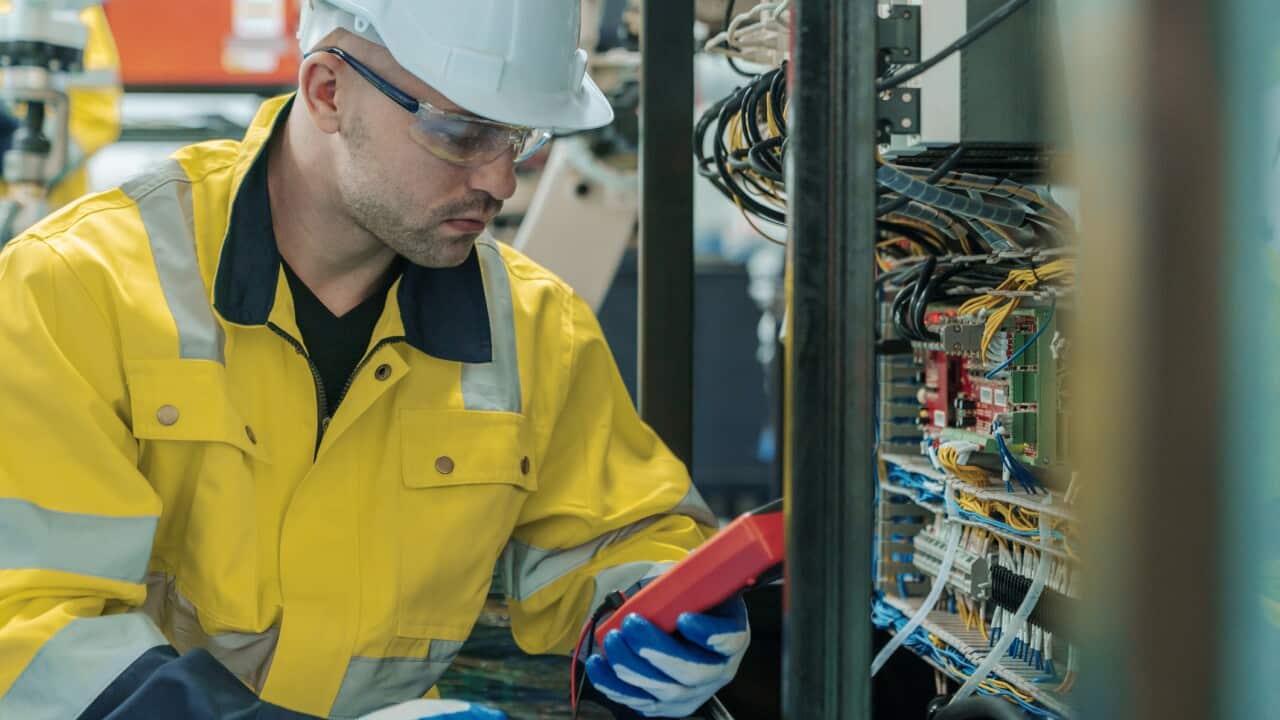 Electrician Engineer work tester measuring voltage and current of power electric line in electrical cabinet control.