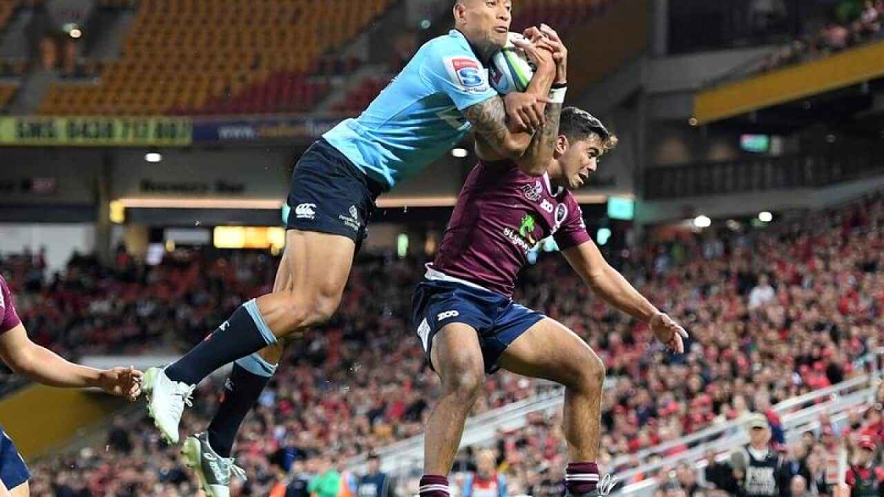 Israel Folau of the Waratahs (l) takes a high kick over Jayden Ngamanu