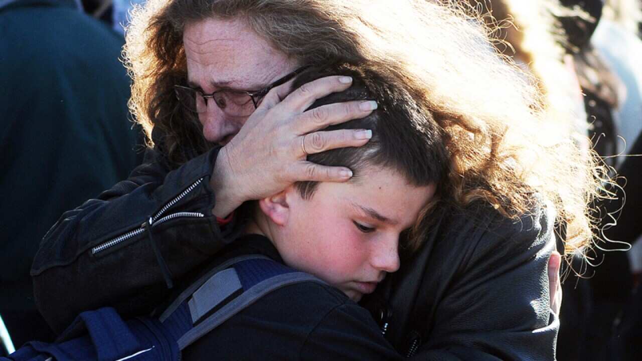 A woman hugs a student near Berrendo Middle School