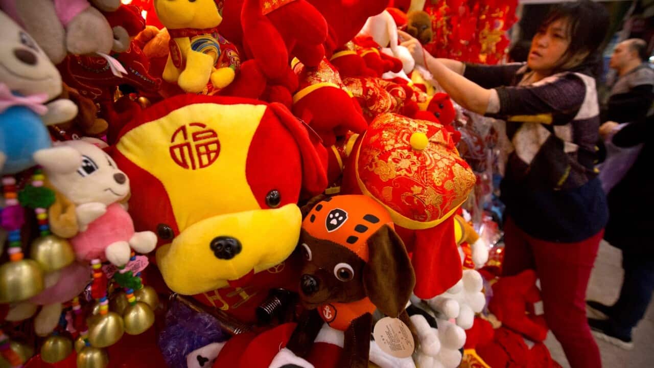 A vendor selling Lunar New Year decorations adjusts a display of stuffed animals at a wholesale market in Beijing, Tuesday, Feb. 13, 2018. 
