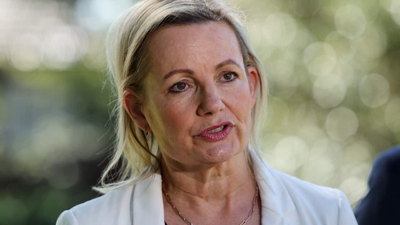 A woman in a white blazer.