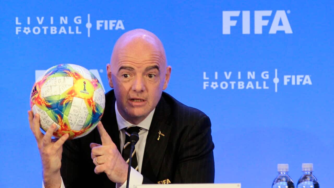 FIFA President Gianni Infantino holds a football.