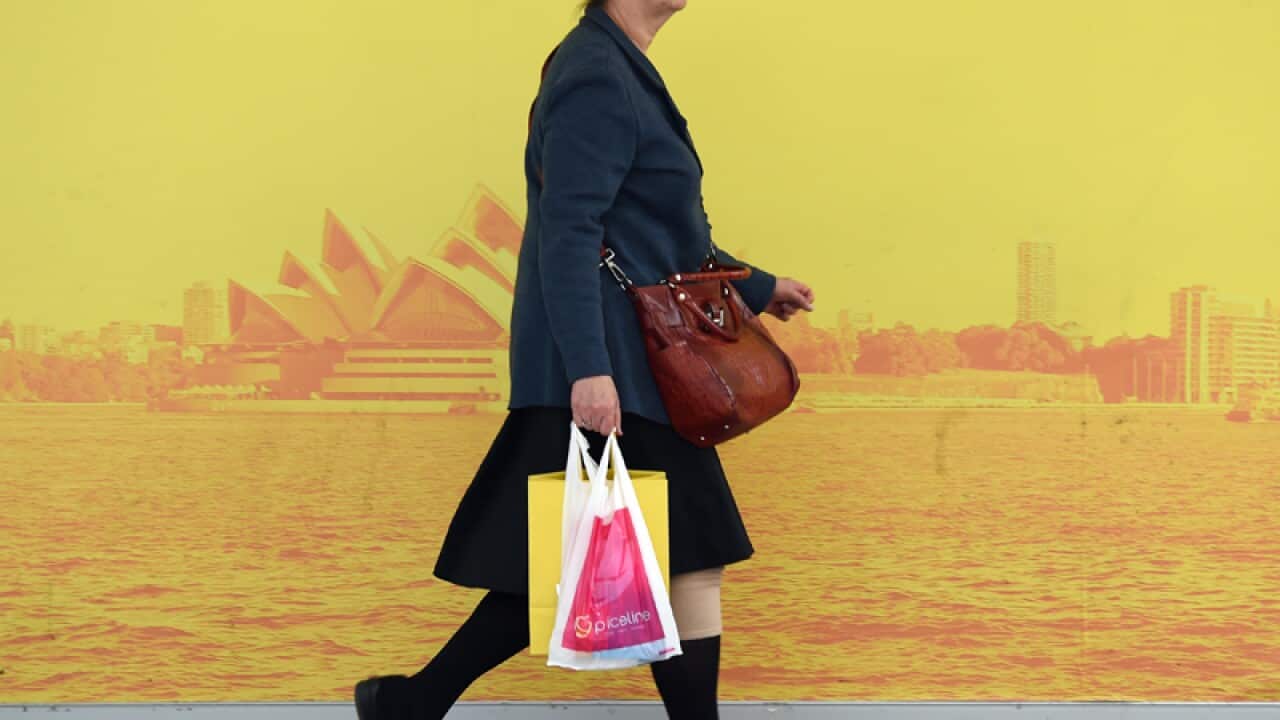 A shopper carries a bag from a retail store in Sydney