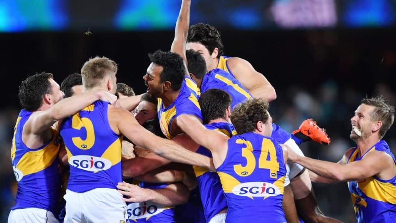 West Coast players celebrate after winning Round 21.