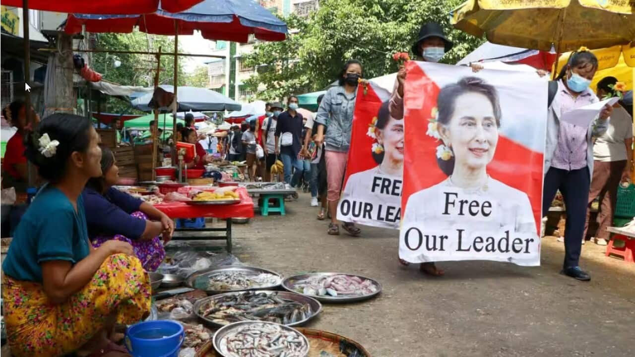 Anti-coup protesters walk through a market Source AAP.jpg