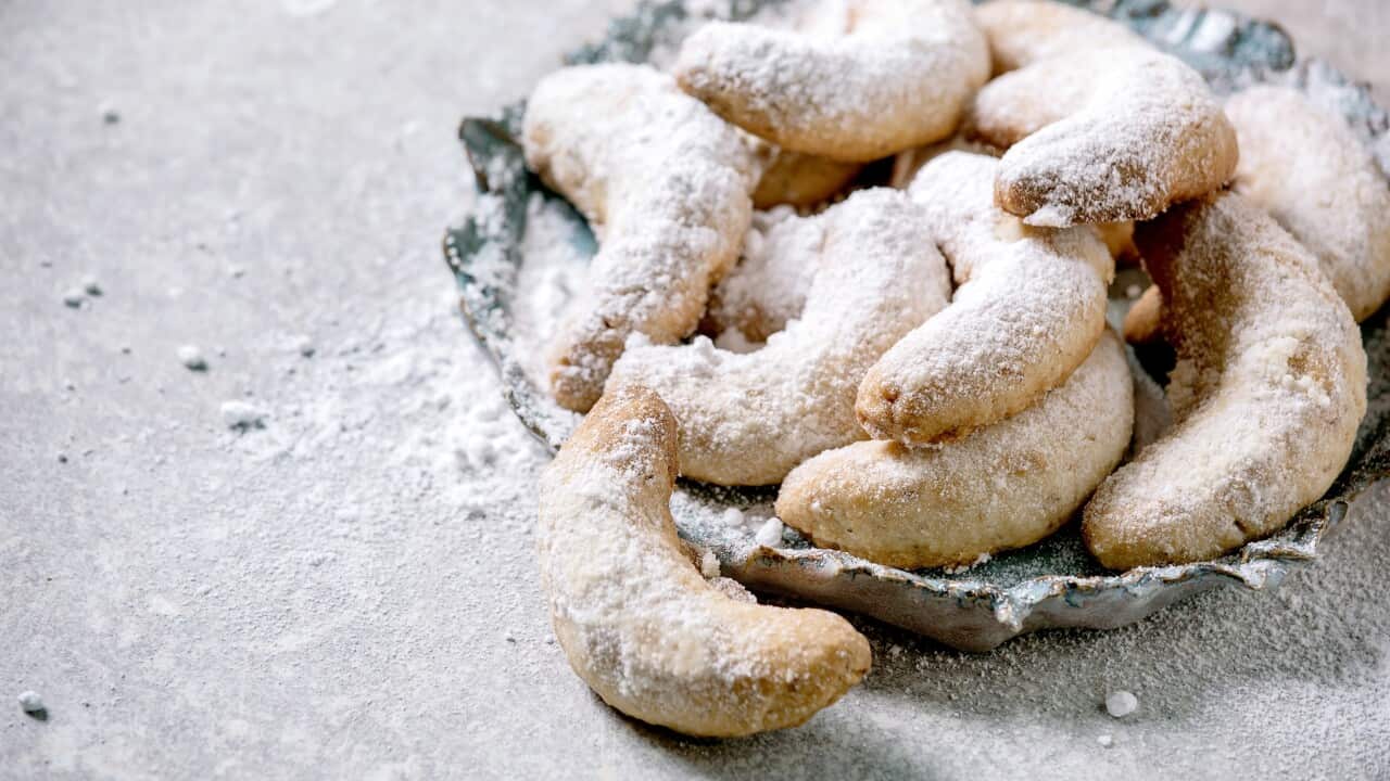 Homemade traditional Christmas shortcrust cookies vanilla crescents with icing sugar. On ceramic plate over light grey background. Close up