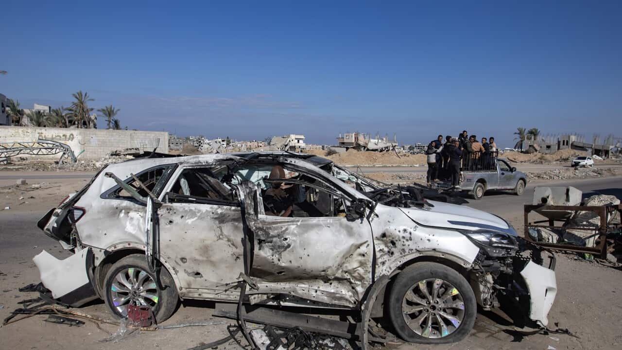 A burnt-out car on the side of a road