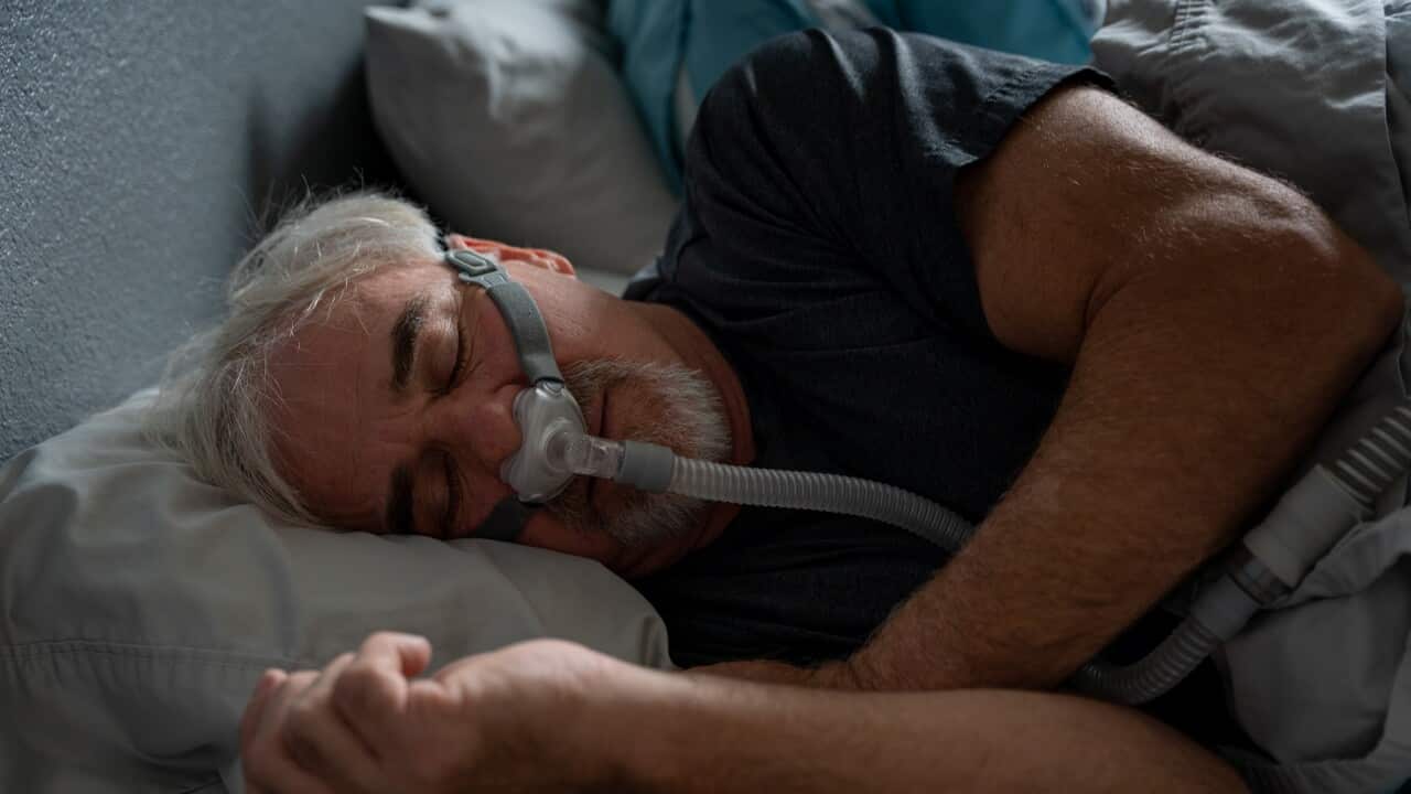 Mature Man With Sleep Apnea Wearing A CPAP Mask In Bed Sleeping