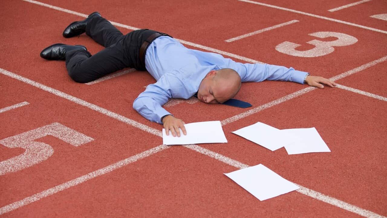 View of a businessman lying on a race track