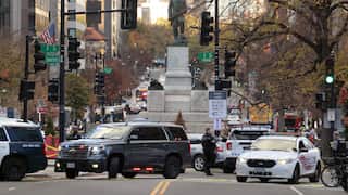 Police cars and members block a city a street in Washington DC in response to the shooting of two National Guard members.