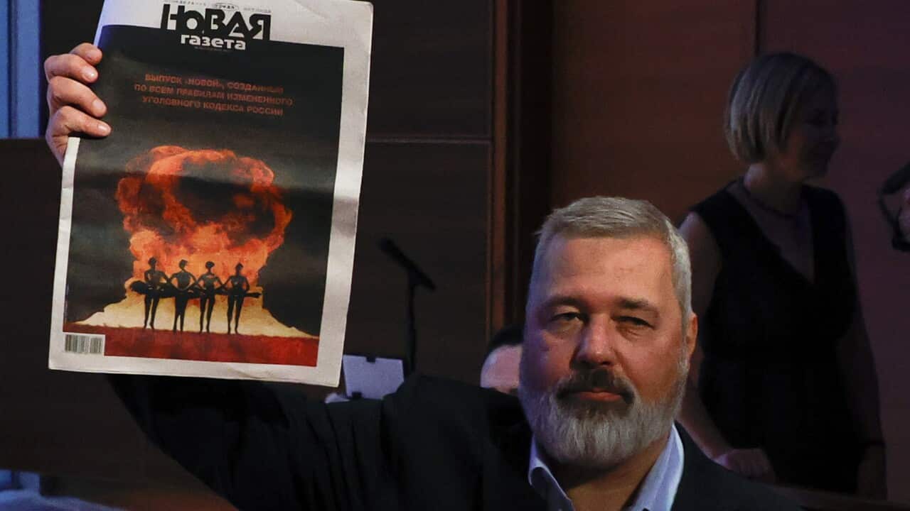 Russian journalist Dmitry Muratov holding up a copy of his newspaper.