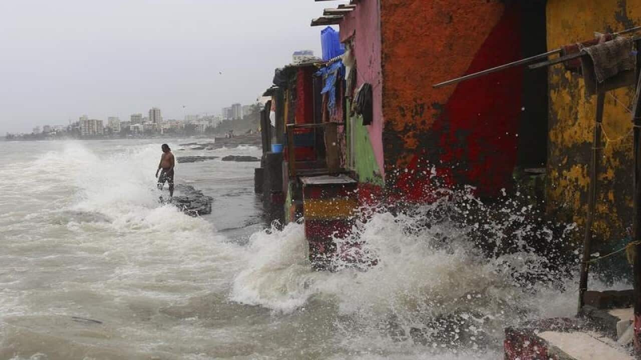 Waves caused by high tide hit the huts on the Indian coast.