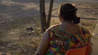 A shot of a Solomon Islander woman wearing a colourful dress, taken from behind.