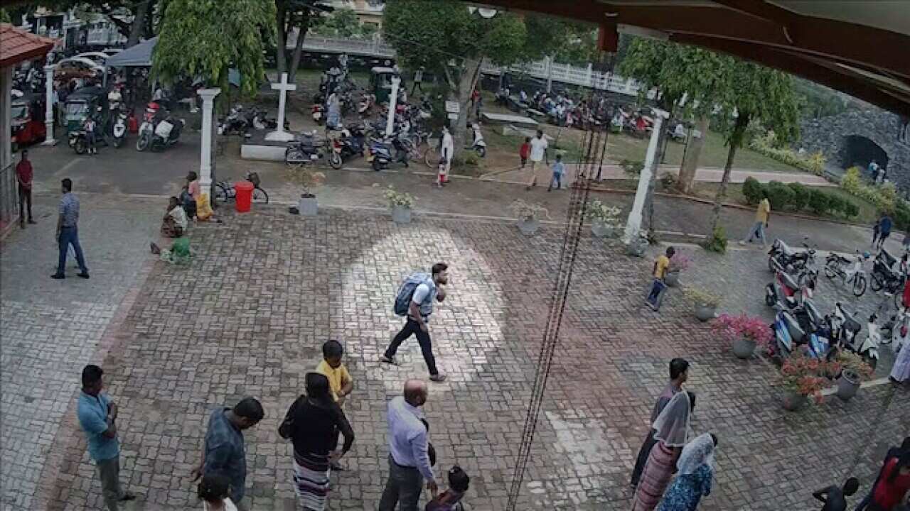 The footage shows a man wearing a large backpack calmly walking towards St Sebastian's church.