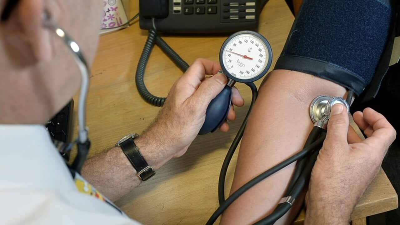 A doctor checking a patient's blood pressure