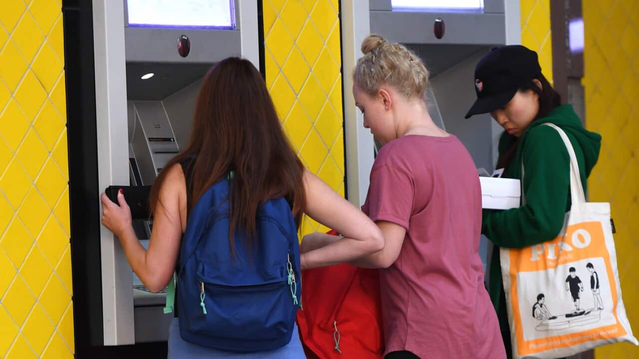 Bank customers using ATM machines