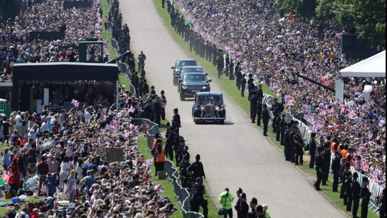 Police line the route as thousands line the route to the wedding.