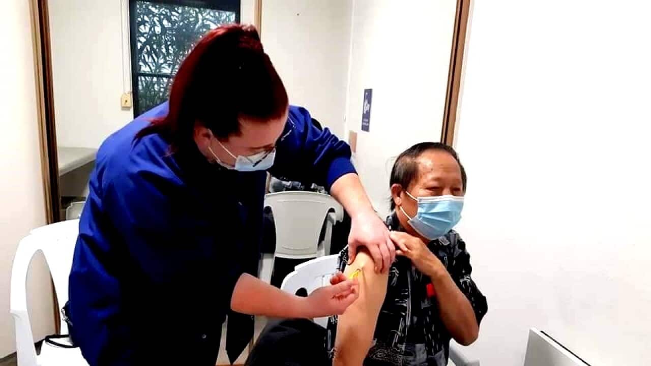 A nurse is giving AstraZeneca vaccine to Mr Vangma Vang (Pat Virathone)