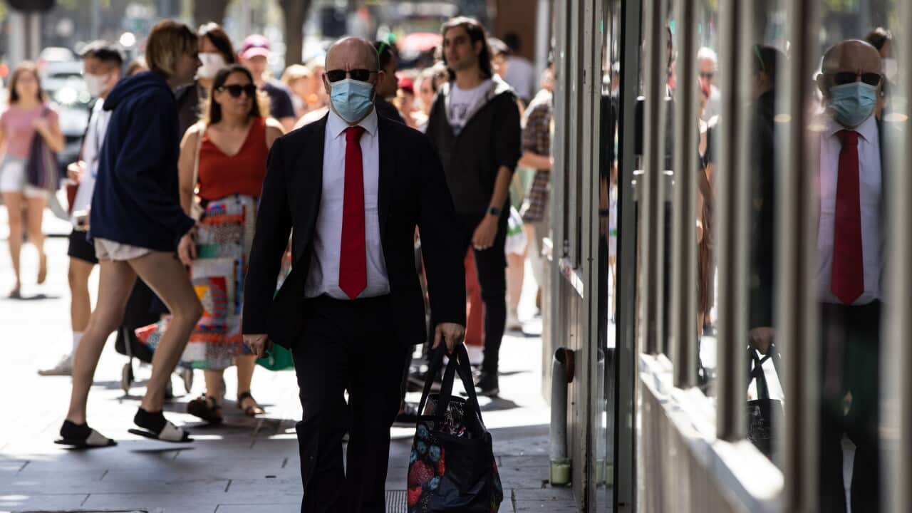 An image of a man walking down Elizabeth Street in Melbourne