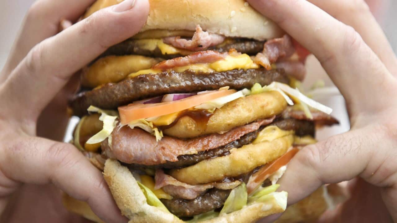 A person eating a very large hamburger