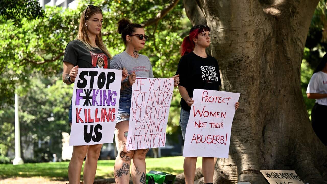 People hold signs during a rally.