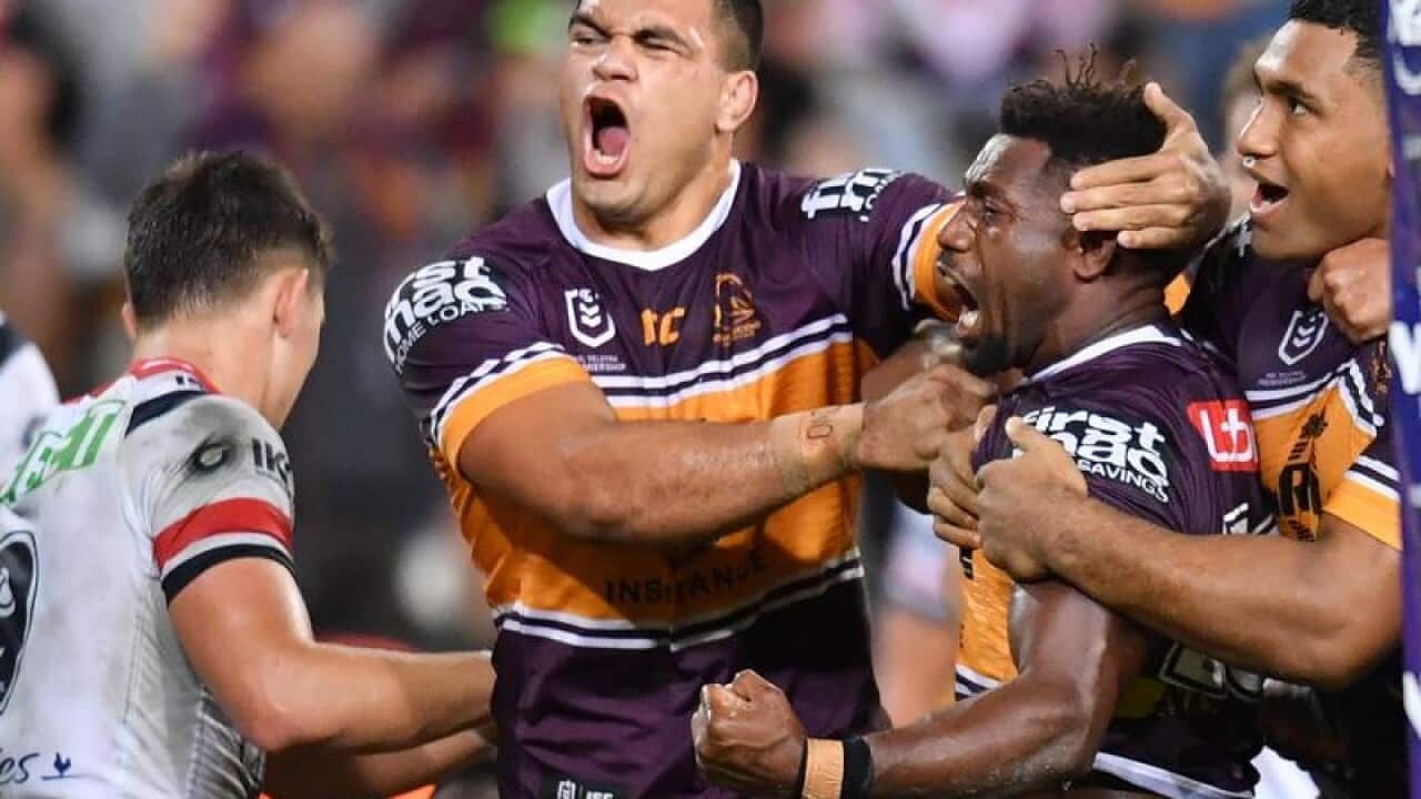 Broncos players David Fifita and James Segeyaro celebrate scoring.
