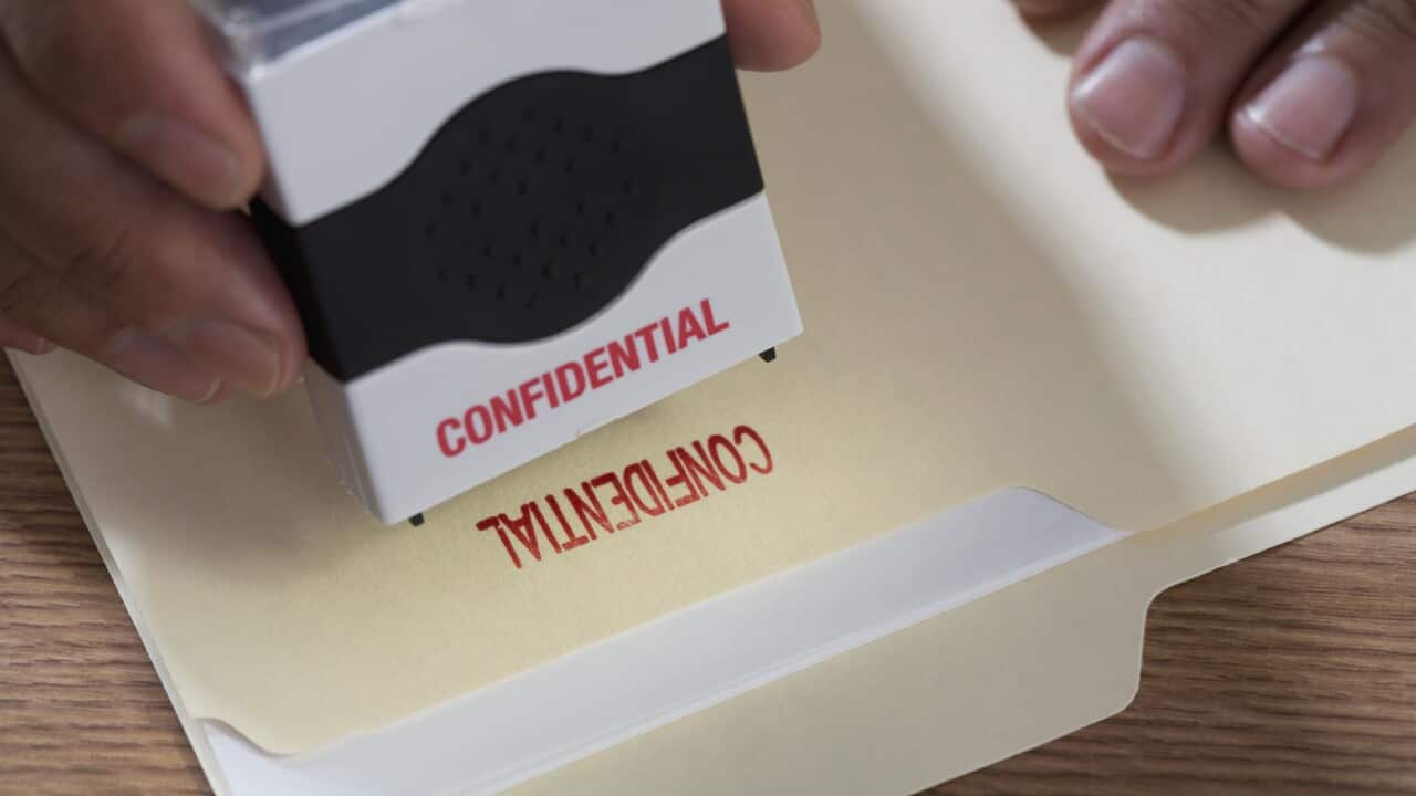 Close up of male hands using confidential stamp on file