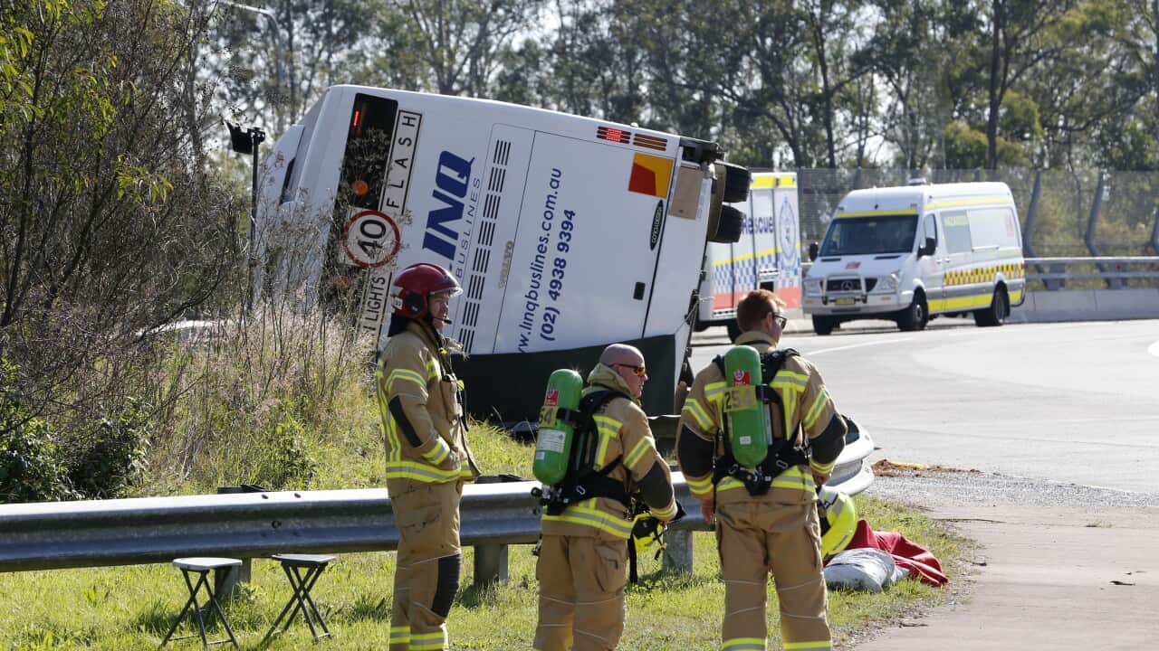 Emergency responders stand near remnants of bus crash