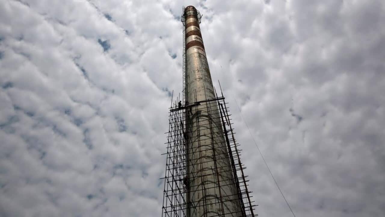Chinese workers at work on demolishing a smoke funnel of a coal heating plant in Beijing, China, 17 June 2013