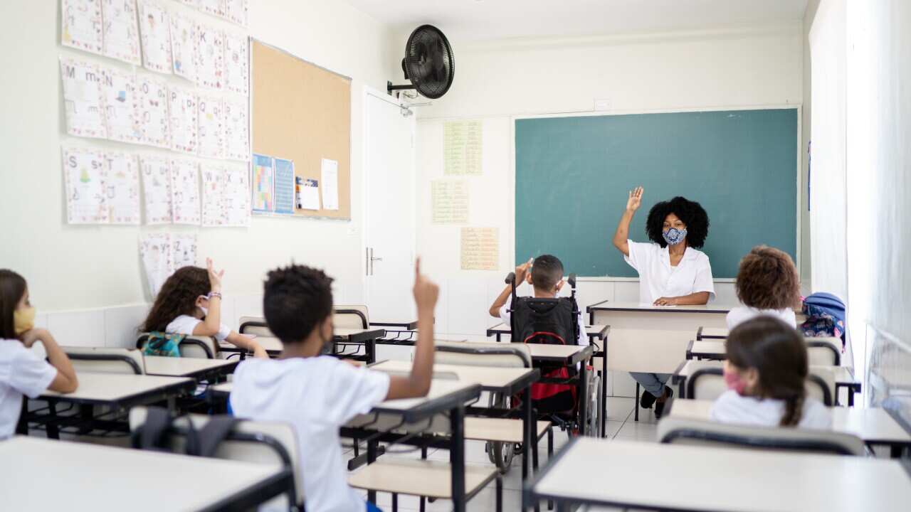 Teacher teaching in classroom respecting social distancing between students