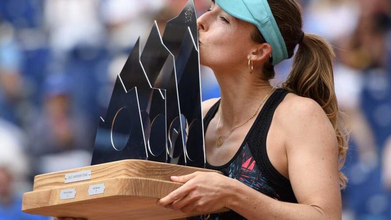 French tennis player Alize Cornet celebrates with the trophy