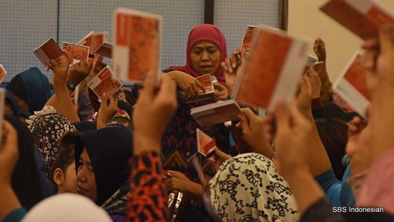Social Affairs Minister Khofifah Indar Parawansa (center) distributes savings books in Depok, West Java, 18 Nov 2017.