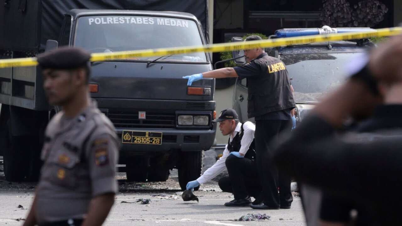 Members of police forensic team inspect the site of a bombing attack at the local police headquarters in Medan, North Sumatra, Indonesia, Wed, Nov. 13, 2019.