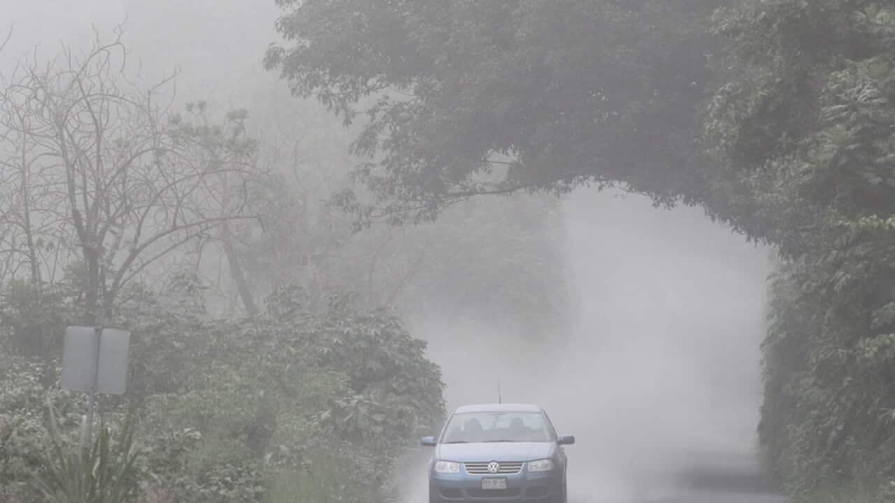 A vehicle is seen crossing a road covered in ash