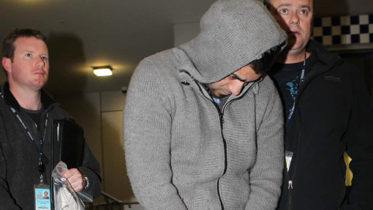 Suhan Rahman (C) is escorted by police