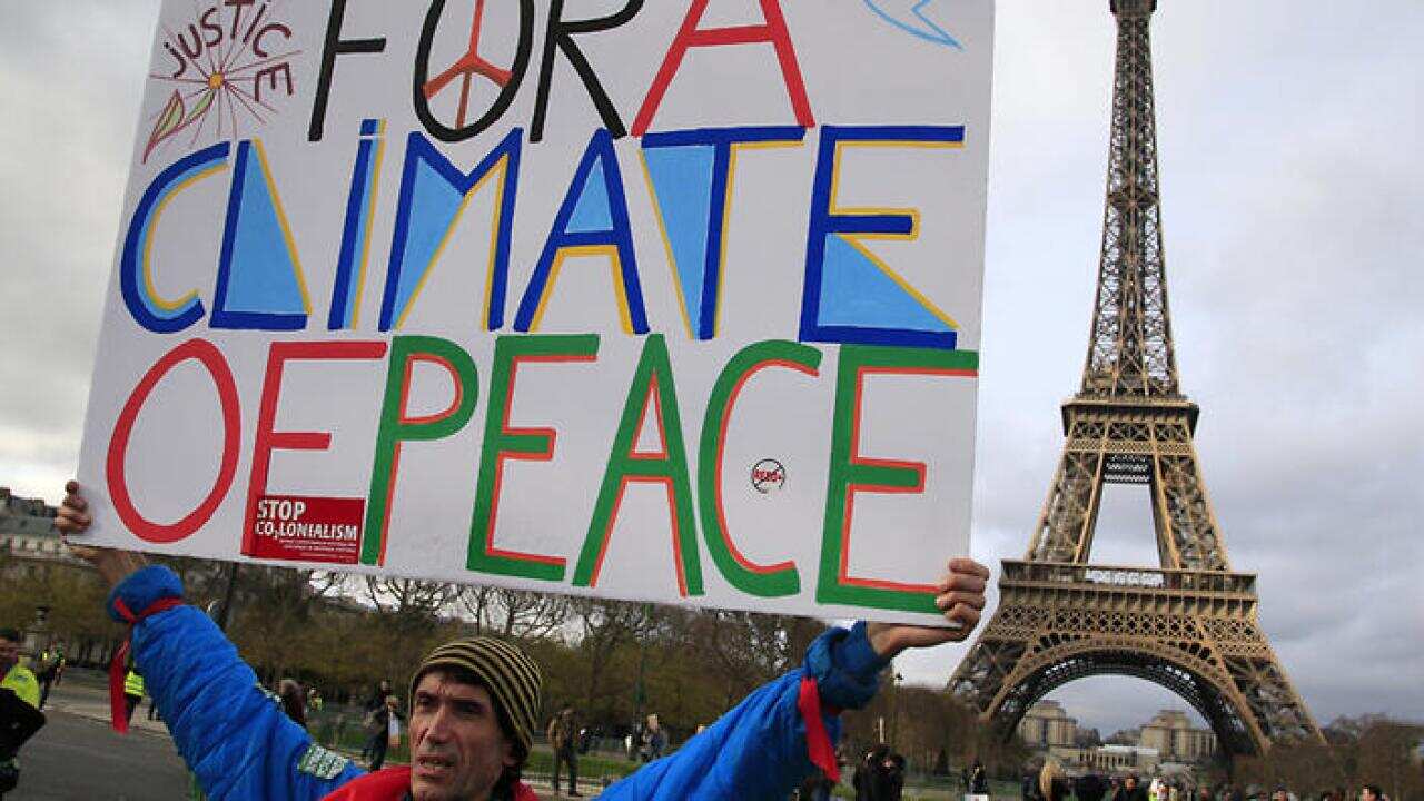 An activist hold a poster during a demonstration near the Eiffel Tower, in Paris