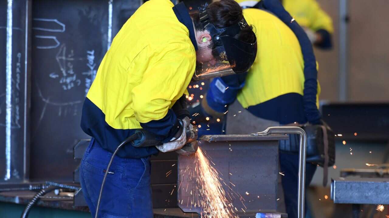 Workers are seen on a production floor at an engineering facility