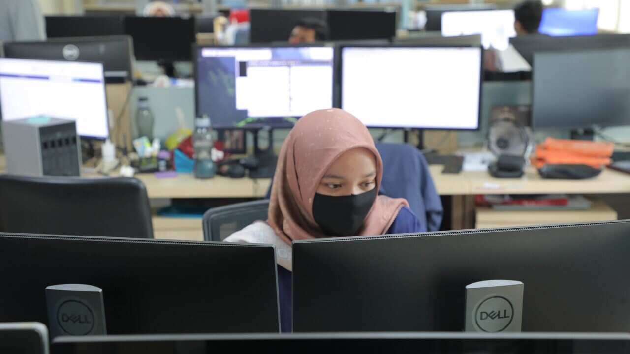 A worker wears a face mask in the office (AAP)