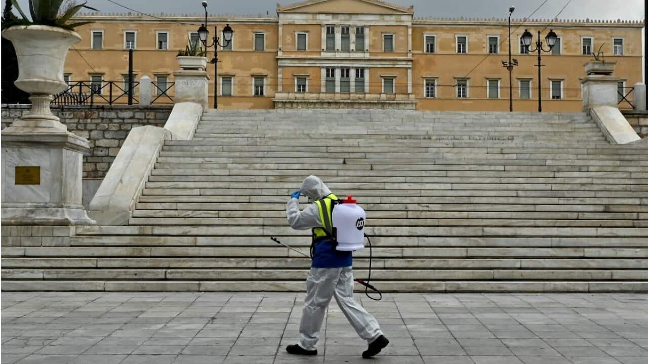 A municipal worker disinfects Syntagma square.