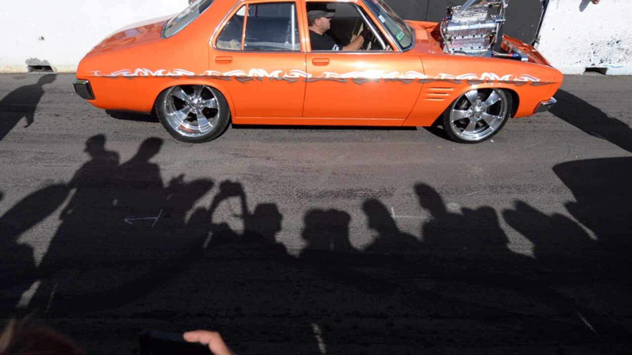 Spectators cheer as a car passes by during the Summernats festival