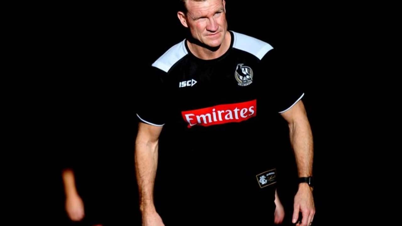 Magpies' Coach Nathan Buckley walks up the players race.