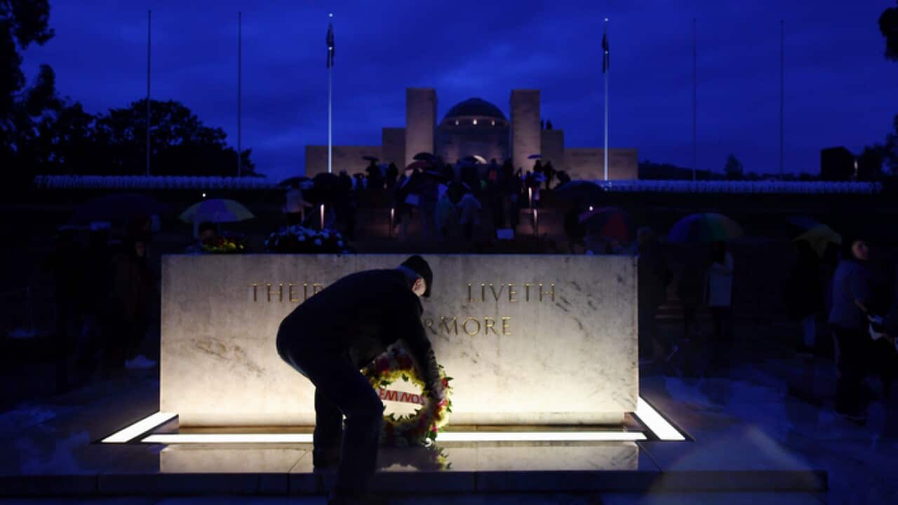 A man places a wreath at the stone of remembrance at the Australian War Memorial