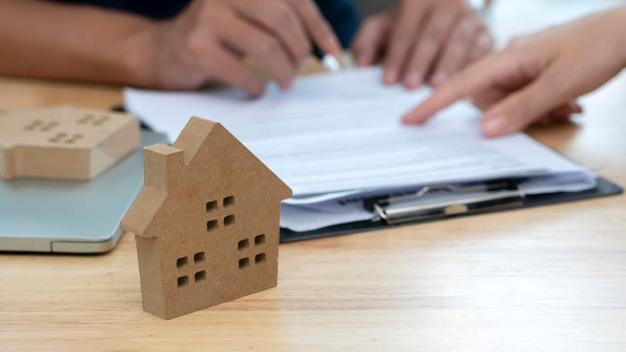 Customer signing a real estate contract in real estate agency.