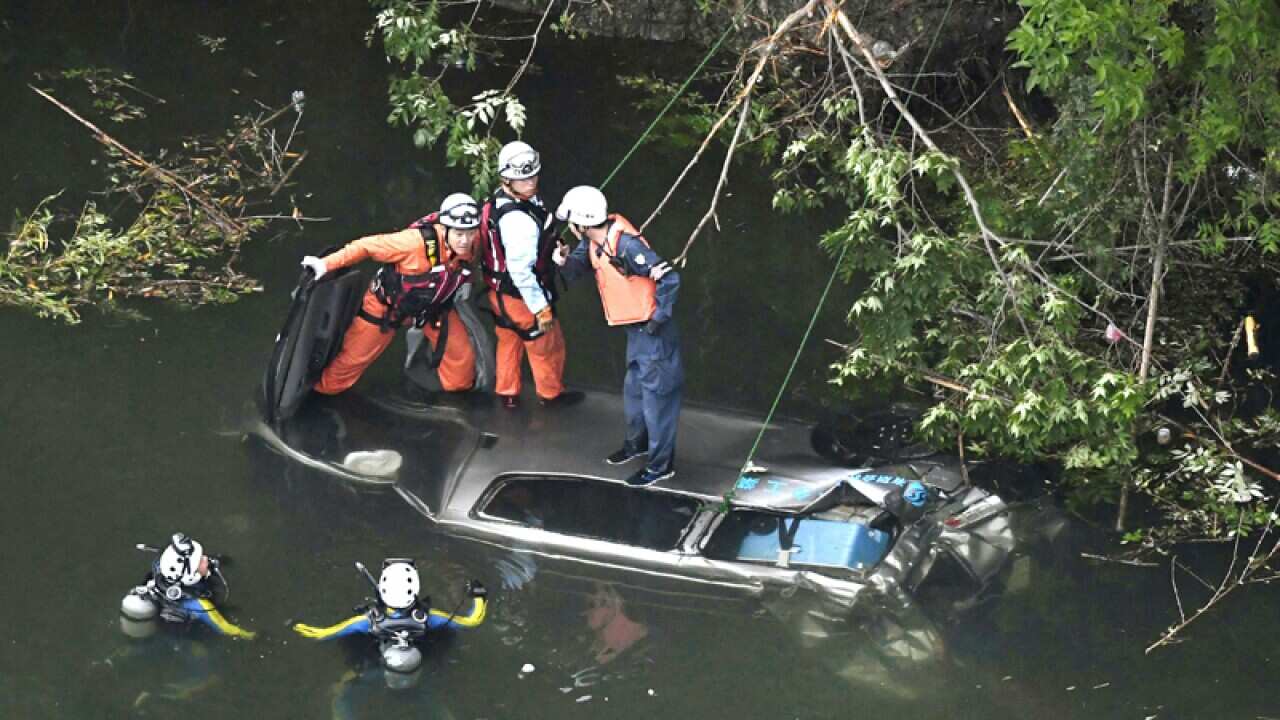 Investigators examining a sunken van in a dam reservoir in Japan