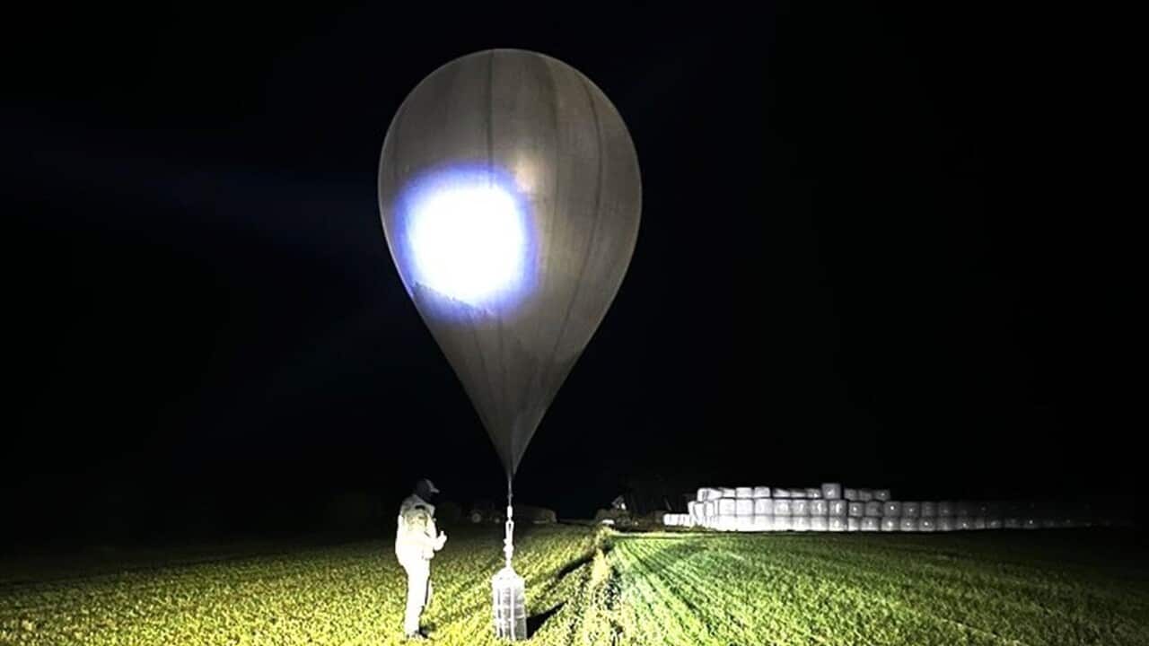 An officer inspects a balloon used to carry cigarettes from Belarus into Lithuania.
