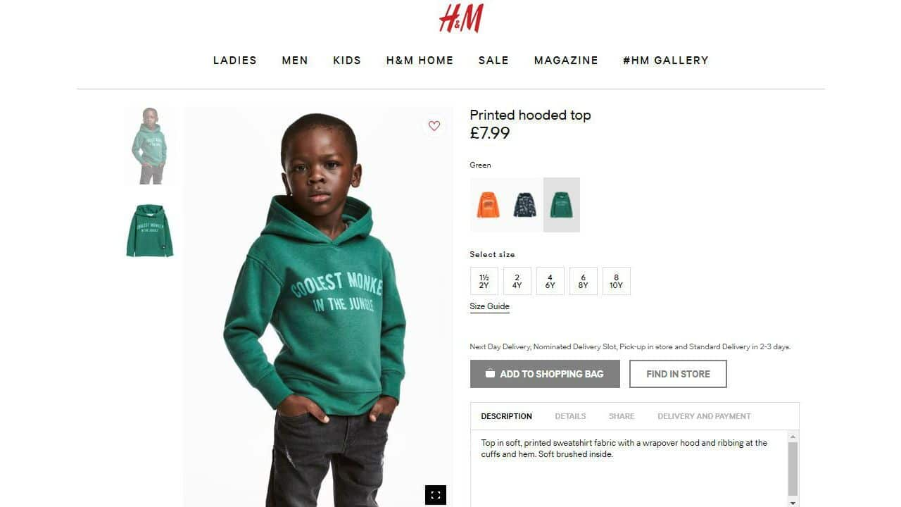 A black boy models a hoodie with the slogan 'Coolest Monkey in the Jungle'.