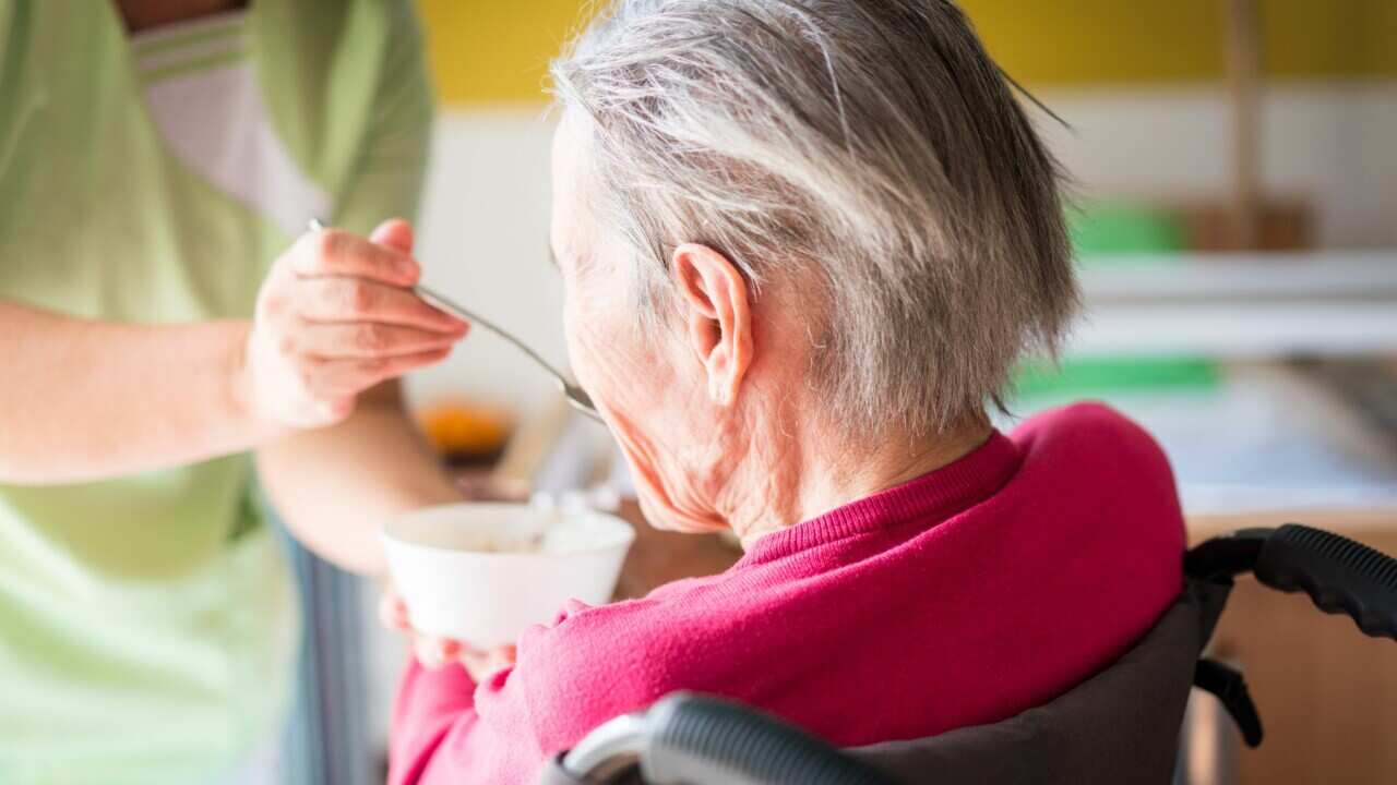 Elderly woman being fed